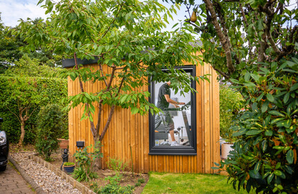 Garden room gym with man working out on treadmill